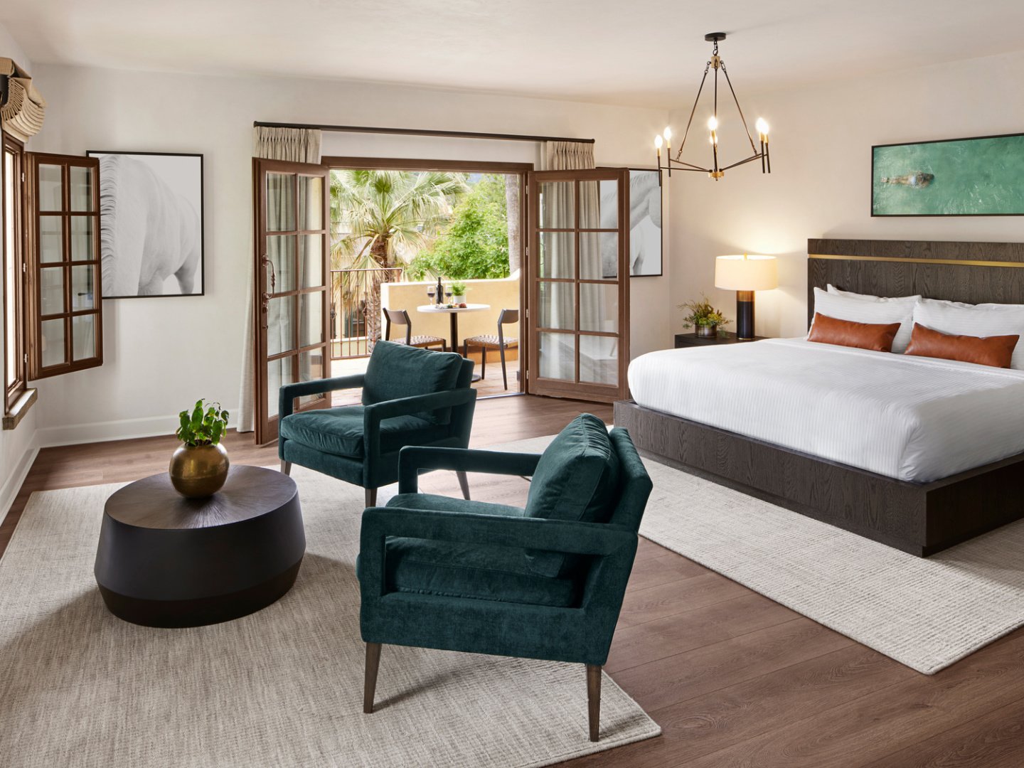 Luxury boutique hotel room with velvet chairs in front of fireplace.